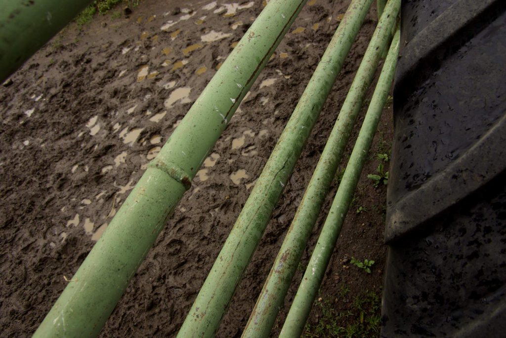 green iron bars, mud and tire in a farm