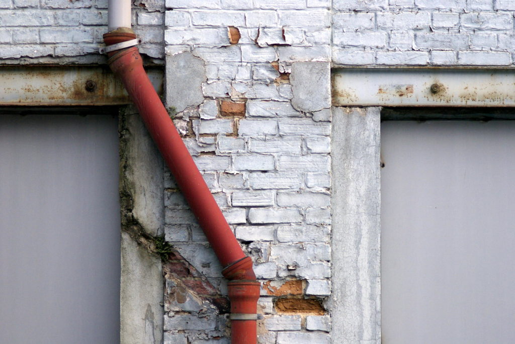 red gutter on a brick wall